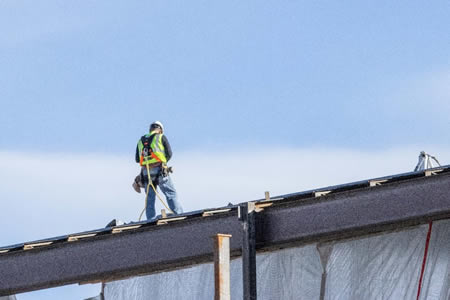 Commercial roof replacement crew staging materials in lafayette before hurricane season